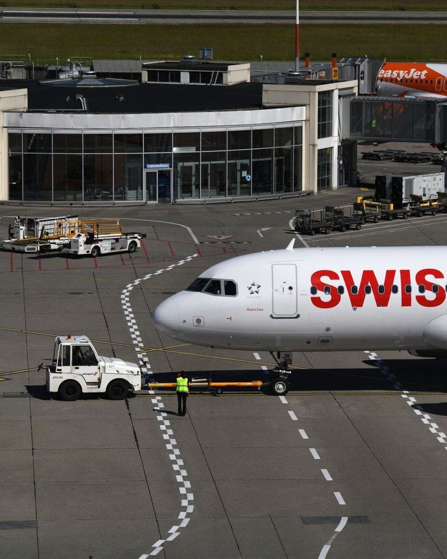Covered car park at Geneva Airport, rows of cars beneath the level signs