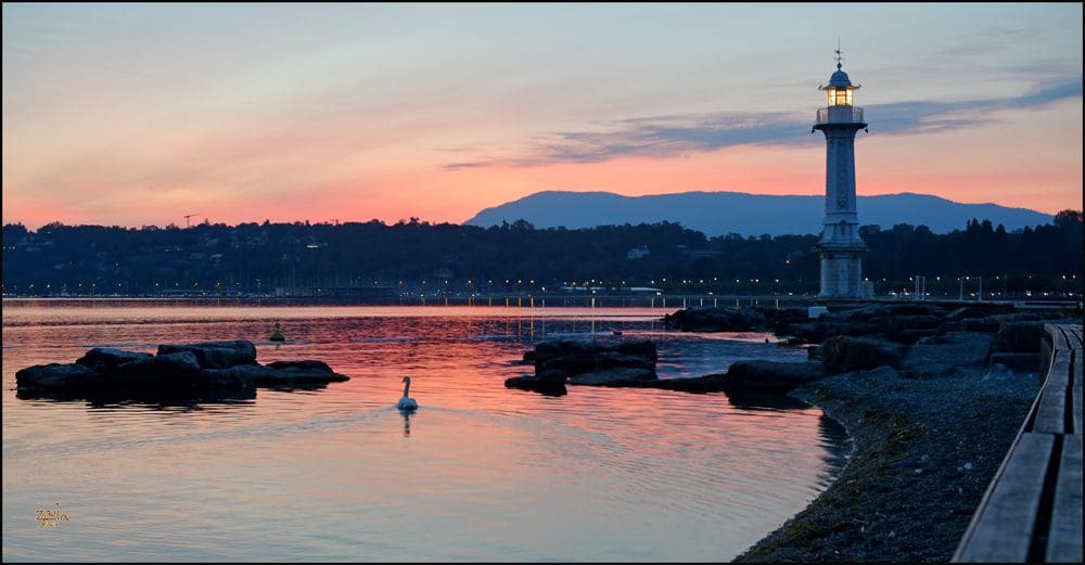 Die Bains des Pâquis in der Abenddämmerung, mit dem Leuchtturm der Mole und dem noch hellen See