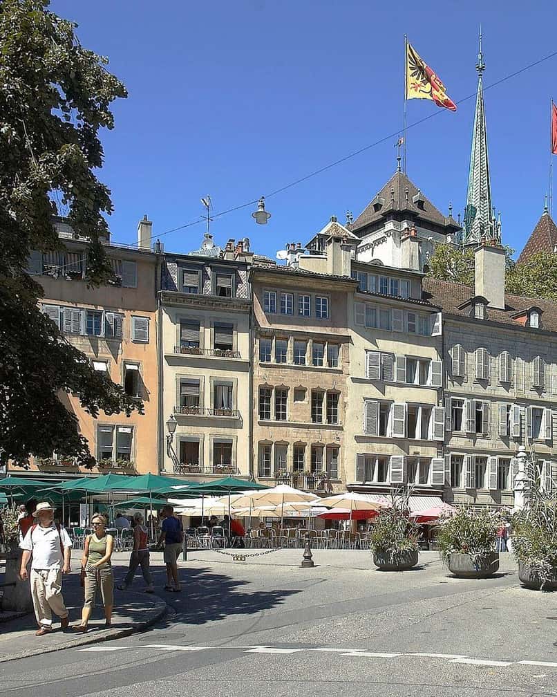 Die Place du Bourg-de-Four in der Genfer Altstadt, ihr Brunnen und die Caféterrassen auf dem Pflaster