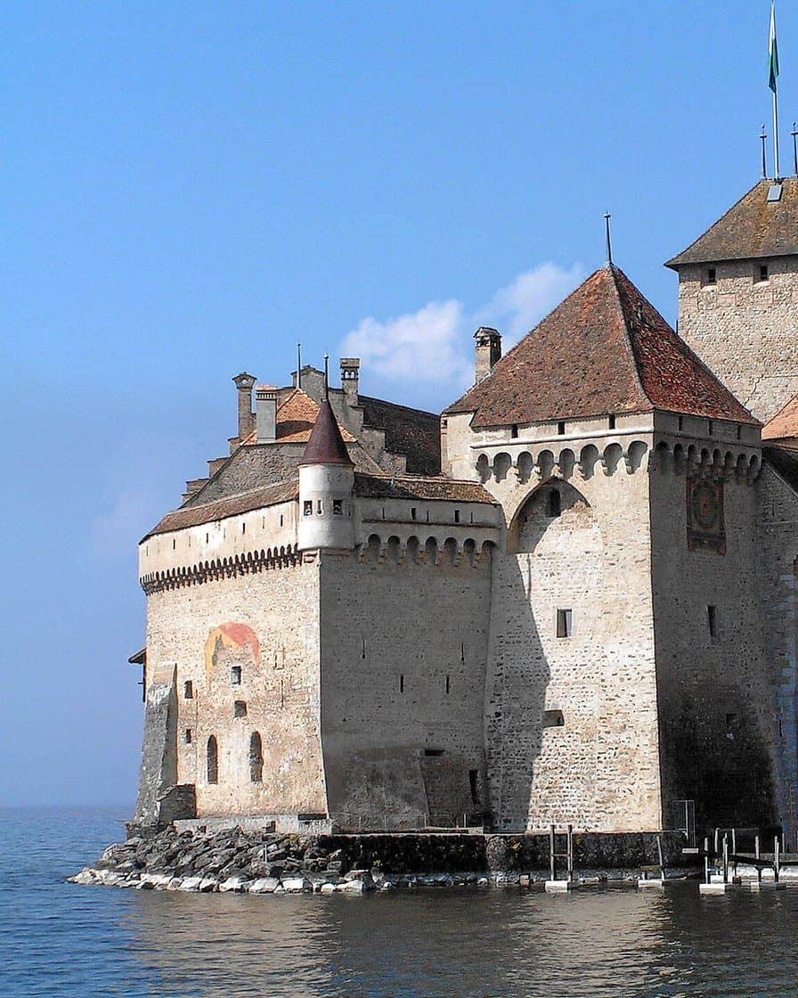 Il castello di Chillon su uno scoglio in riva al lago Lemano, vicino a Montreux, con le montagne sullo sfondo