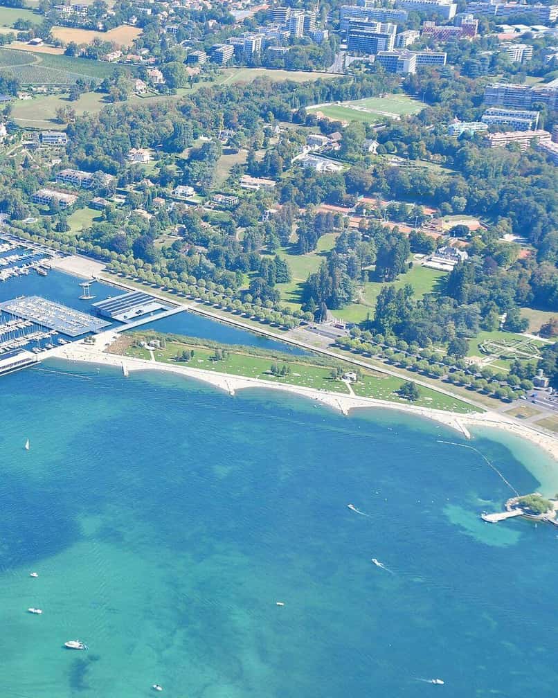 Der öffentliche Strand von Eaux-Vives in Genf, seine Sitzstufen und der Zugang zum Genfersee, mit dem Jet d'eau ganz in der Nähe