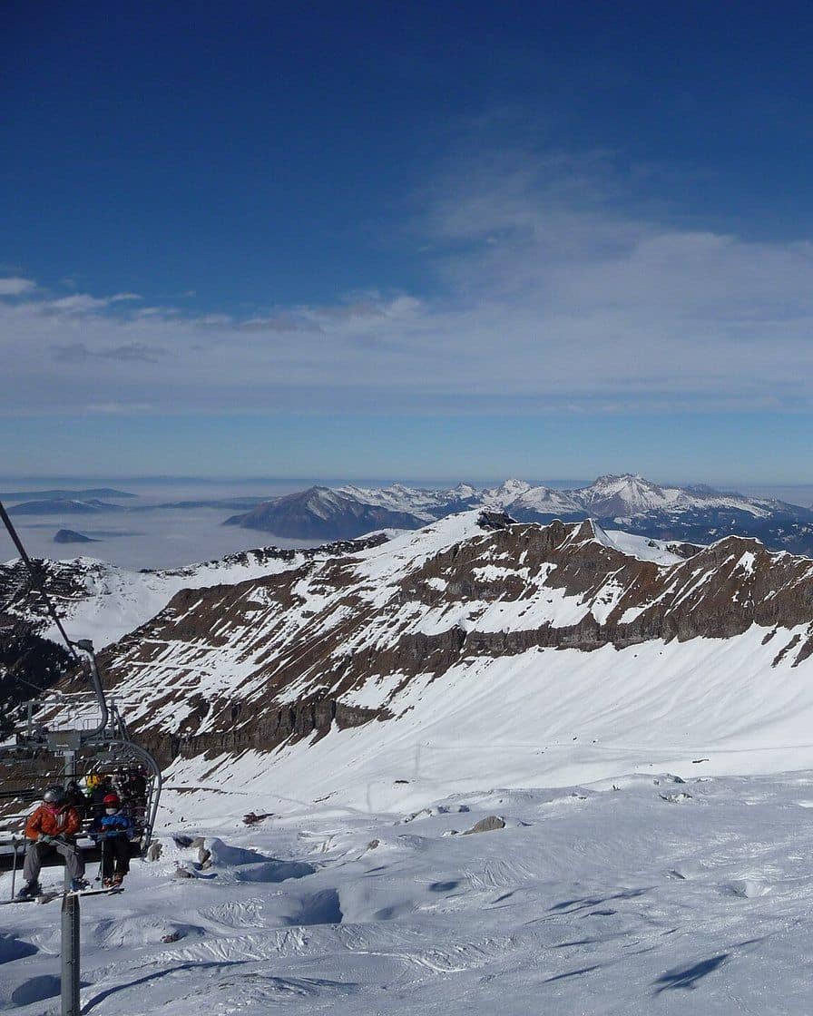 Pistes de ski de Flaine en Haute-Savoie sous un ciel bleu, avec des skieurs et les sommets enneigés du Grand Massif