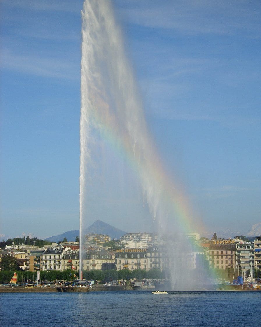 The Geneva Jet d'eau shooting 140 metres above the harbour, a white plume against the blue sky and the mountains