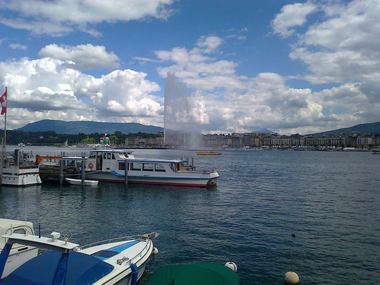 Die Genfer Bucht und der Jet d'eau, im Vordergrund vertäute Boote, in der Ferne der Salève