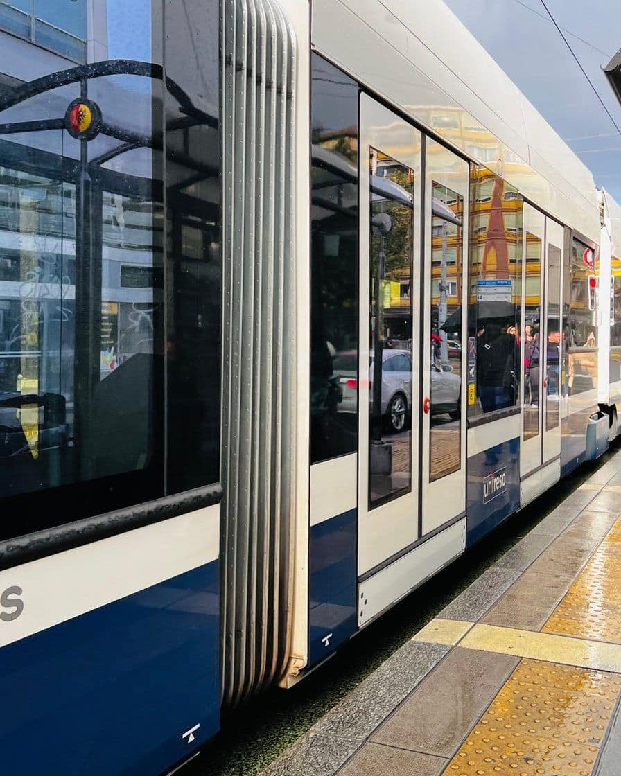 Transports publics genevois tram at the Rive stop on Geneva's left bank, with passengers boarding